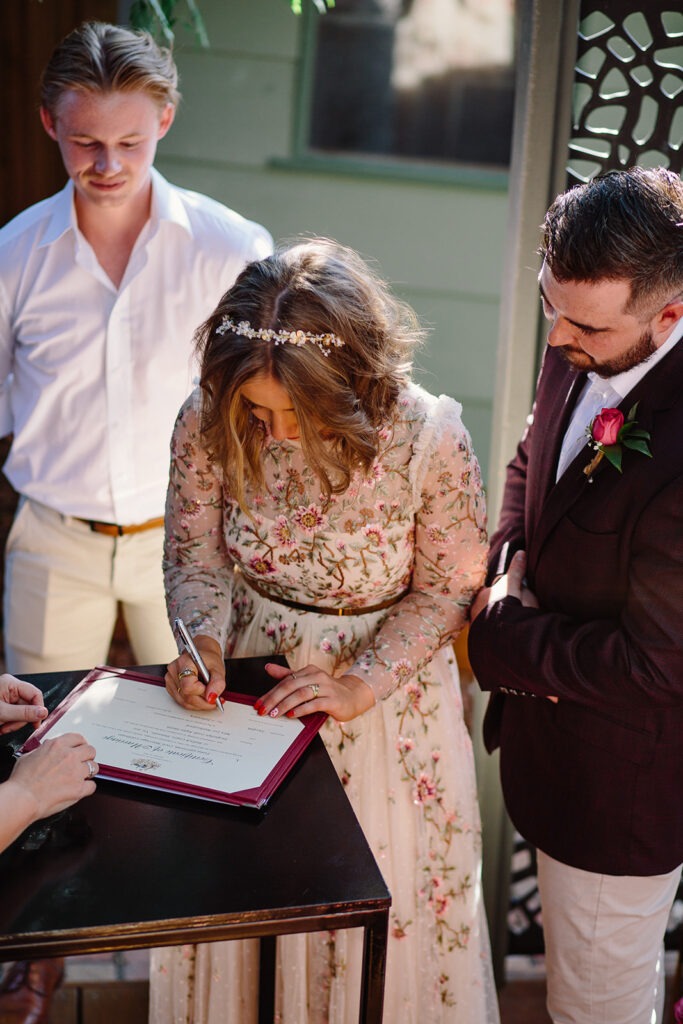 Couple signing papers at backyard wedding